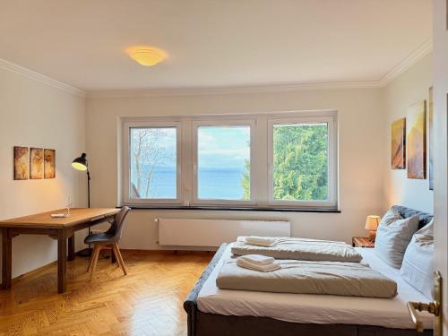 a bedroom with two beds and a desk and a window at Ferienwohnung Seeperle49 WG2 - Besonders, stilvoll mit eigenem Badestrand in Nonnenhorn