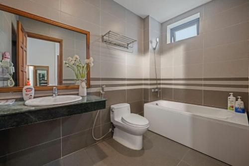 a bathroom with a toilet and a sink and a bath tub at Villa Da Nang Hoang Sa in Da Nang