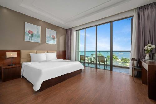 a bedroom with a large white bed and a large window at Villa Da Nang Hoang Sa in Da Nang