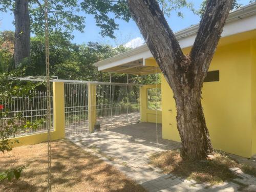 a yellow house with a tree and a swing at Peaceful and beautiful Casa Almita Bonita in Sámara