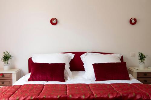 - un lit rouge et blanc avec 2 oreillers rouges dans l'établissement Standing de 88 m2, grand jardin, wifi, clim, Netflix, La Suzanna, à Hyères
