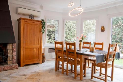 une salle à manger avec une table et des chaises et une cheminée dans l'établissement Standing de 88 m2, grand jardin, wifi, clim, Netflix, La Suzanna, à Hyères