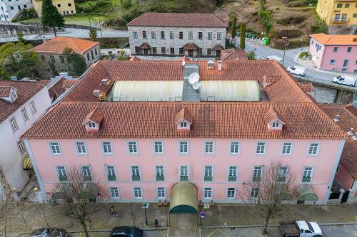 an overhead view of a pink building with a red roof at Hotel Universal in Geres