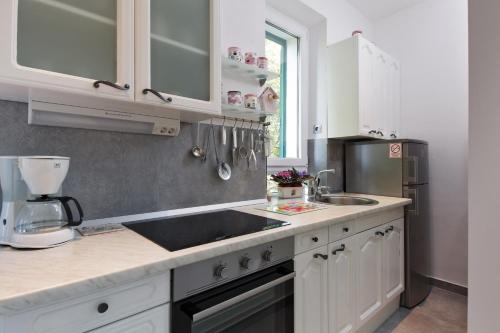 a kitchen with white cabinets and a sink at Apartments Kala & Kaleta in Split