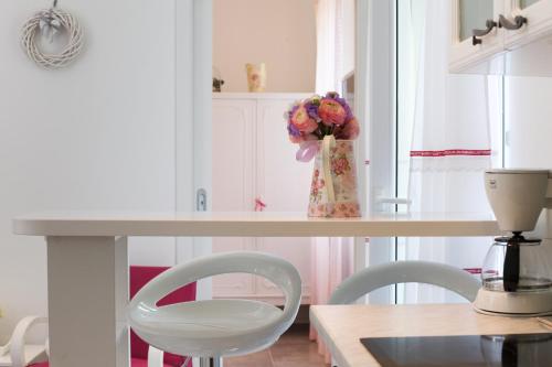 a kitchen with a table with a vase of flowers at Apartments Kala & Kaleta in Split