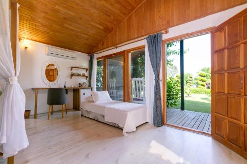 a bedroom with a bed and a large window at Etenna Beach Bungalows in Cıralı