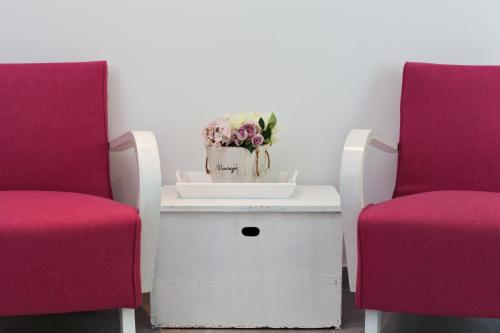 two chairs sitting next to a table with a vase of flowers at Apartments Kala & Kaleta in Split