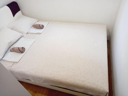 a small bed with white sheets and pillows at B4 in Budva
