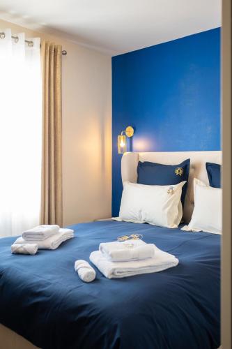 - un lit bleu avec des serviettes dans l'établissement Le domaine de Mika & Nina, à Arles