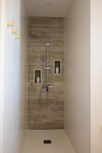 une douche dans une salle de bain avec un mur en bois dans l'établissement Le domaine de Mika & Nina, à Arles
