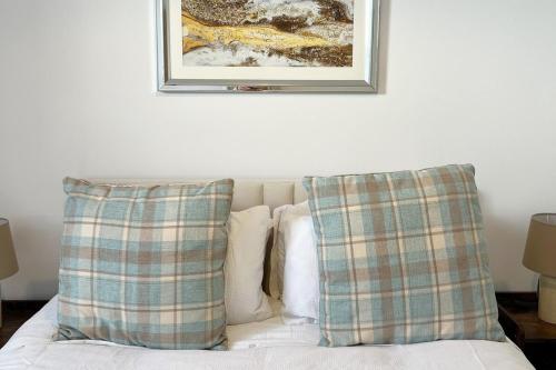 ein Bild, das über einem Bett mit Kissen hängt in der Unterkunft Harbour-side, 2-bed Mews Apartment, in Torquay