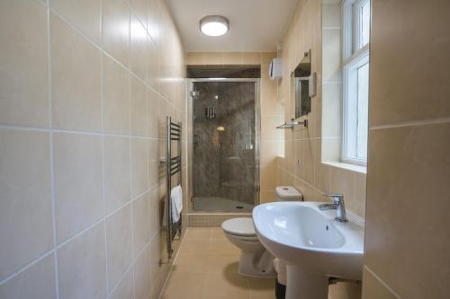 ein Badezimmer mit Waschbecken, Toilette und Dusche in der Unterkunft Harbour-side, 2-bed Mews Apartment, in Torquay