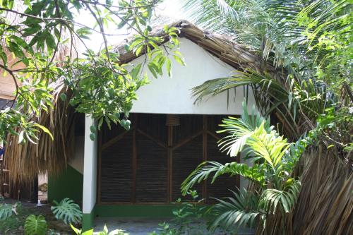 a house with a white roof and some trees at Hostel Nugeku in Rincón