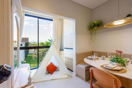 a dining room with a table and a large window at Apto Novo e diferenciado a 500 metros do Alles Park in Pomerode