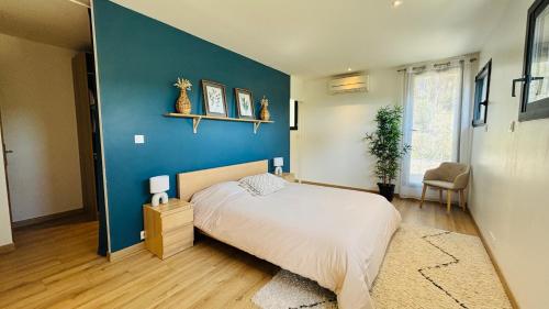 une chambre avec un mur bleu et un lit dans l'établissement Le Secret des Pins, à Pernes-les-Fontaines