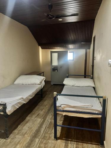 a room with two beds in a room with a mirror at Misty Rosa Resorts Pvt Ltd in Kottayam
