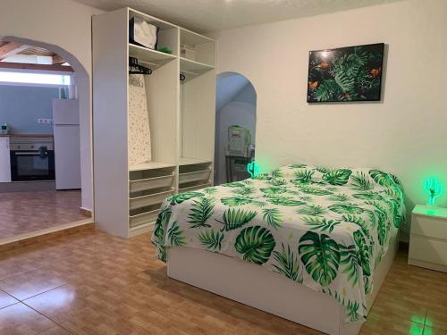 a bedroom with a bed with a green and white comforter at Casamaria in Tarajalejo