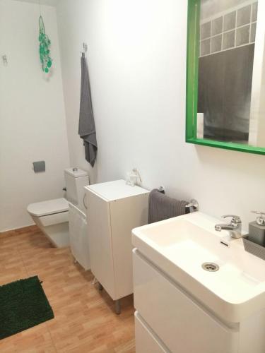 a bathroom with a toilet and a sink and a mirror at Casa maria in Tarajalejo