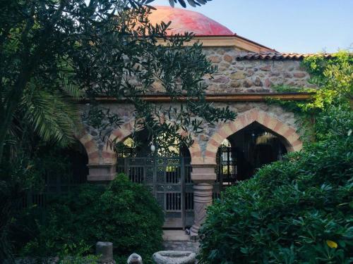 a stone building with a gate with a red dome at Dream House by the Aegean Coast in Dikili