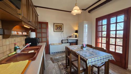 una cucina con un tavolo e un piano di lavoro di Family-friendly apartment in a village house 25 km and 30 mins away from Thessaloniki a Géfyra