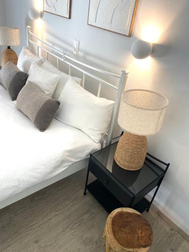 a bedroom with a bed and a table with a lamp at KIPOS-SS residences in Dassia