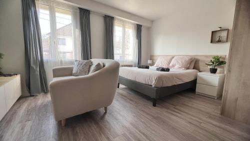 Ozoir-la-Ferrièreにある*Stud'Oz* Paris - Disneyland - Val d'Europeのベッドとソファと椅子のある寝室