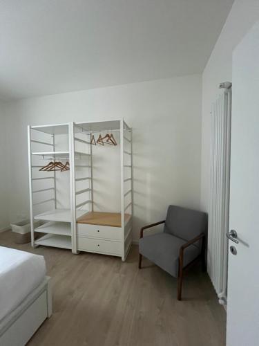 a bedroom with a white cabinet and a chair at AL 31 Bg in Bergamo