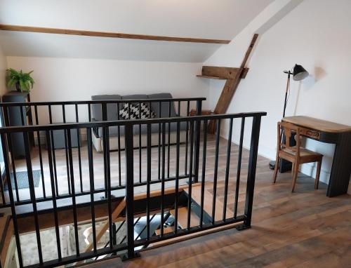 a room with a staircase with a table and a desk at Cidre Bois in Saint-Sulpice-le-Dunois