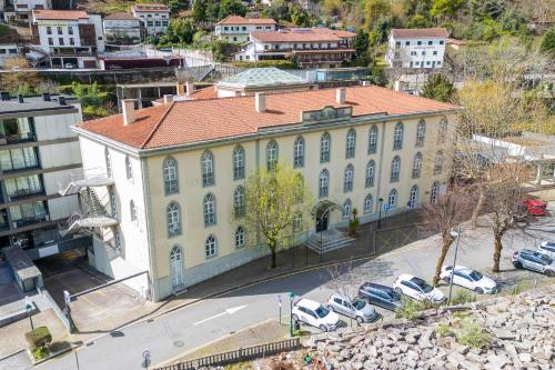 a large yellow building with cars parked in front of it at Hotel Apartamentos Geres Ribeiro in Geres