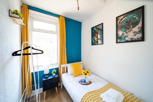 a small room with a bed and a window at Open Mind Property - HotTub, 7 Guests & Parking in Portsmouth