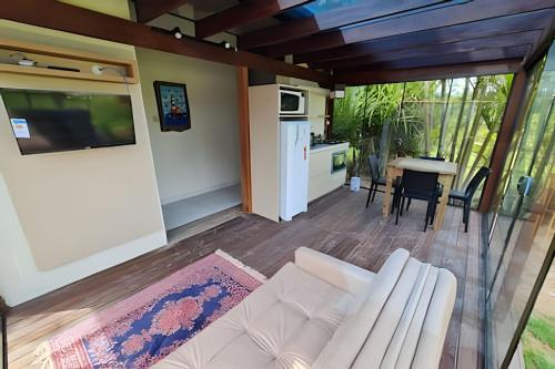 Una sala de estar con un sofá blanco y una mesa. en Condomínio Paraíso do Rosa, en Praia do Rosa