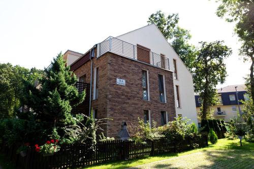 a brick building with a balcony on top of it at Apartament IKAR blisko morza in Rewal
