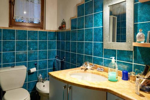 W wyłożonej niebieskimi kafelkami łazience znajduje się umywalka i toaleta. w obiekcie B&B il Patio w Bergamo