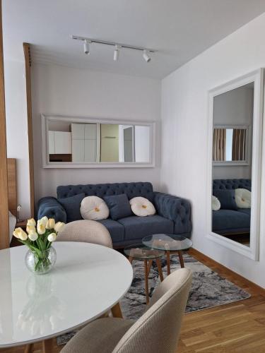 a living room with a blue couch and a table at Sokolis Apartman in Kragujevac