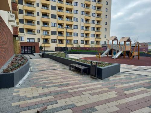 a building with a park with a bench and a playground at Sokolis Apartman in Kragujevac