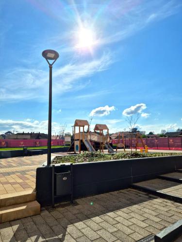 a park with a playground and a light pole at Sokolis Apartman in Kragujevac