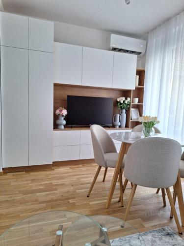 a kitchen with a table and chairs and a television at Sokolis Apartman in Kragujevac