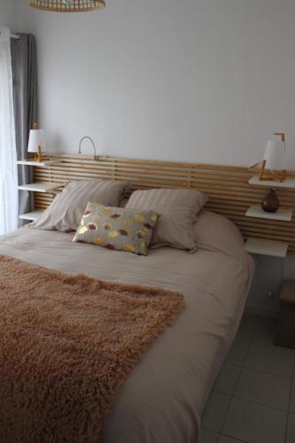 a bed with two pillows on it in a bedroom at Appartement cosy terrasse parking privé 2 vélos in La Rochelle
