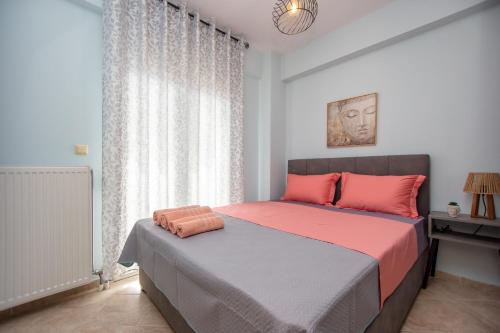 a bedroom with a large bed with pink pillows at Angelica's Apartment in Asprovalta