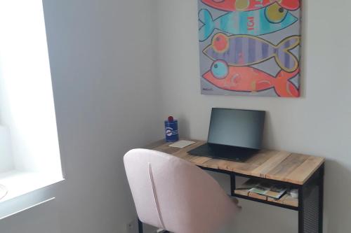 a desk with a laptop computer on top of it at "Ty Nonod" Quiet Breton farmhouse 500m from the sea in Lampaul-Plouarzel in Lampaul-Plouarzel
