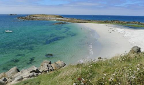 a beach with a group of people in the water at "Ty Nonod" Quiet Breton farmhouse 500m from the sea in Lampaul-Plouarzel in Lampaul-Plouarzel