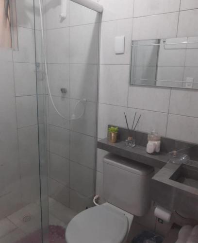 a bathroom with a toilet and a glass shower at Apartamento da Jack in Campina Grande