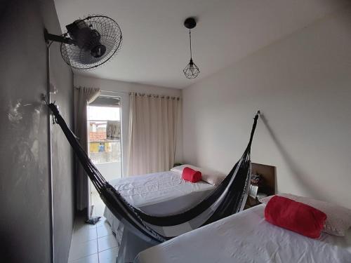 a bedroom with two beds and a hammock at Apartamento da Jack in Campina Grande