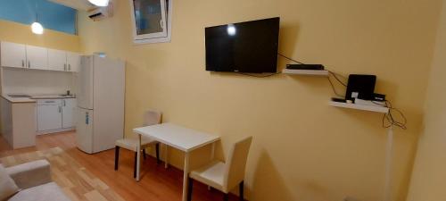 a room with a table and a television on a wall at Apartman Biljana in Novi Sad