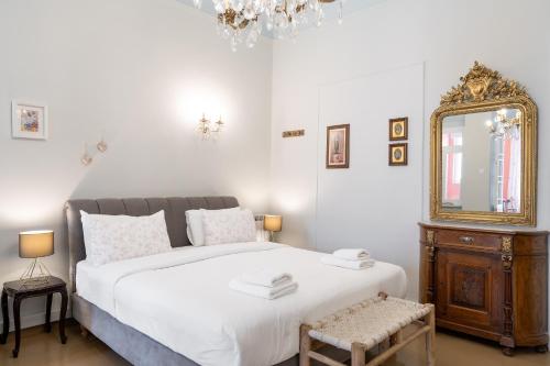 a bedroom with a bed and a mirror and a chair at Neoclassical Mansion in Andros Town by Explore Andros in Andros
