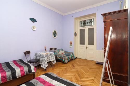 a room with a bed and a table and a door at Leon Rooms in Tbilisi City