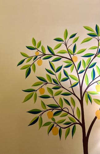 a tree with leaves and oranges on a wall at The Mango Tree by ANAND VILLA in Jodhpur