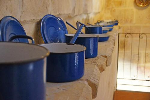 a row of blue pots and pans on a wall at Luciano Valletta Boutique in Valletta