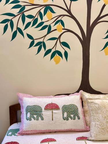a bedroom with a tree and two elephants with an umbrella at The Mango Tree by ANAND VILLA in Jodhpur