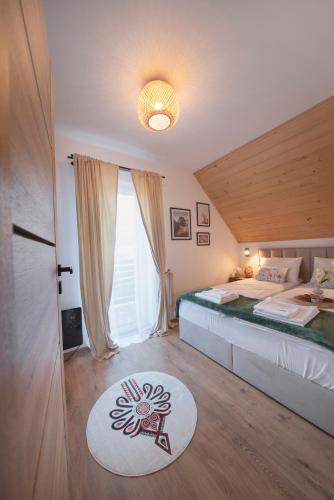 ein Schlafzimmer mit einem großen Bett und einem großen Fenster in der Unterkunft MICHAŁÓWKA - Domek w Górach przy Lesie - Energylandia in Targanice